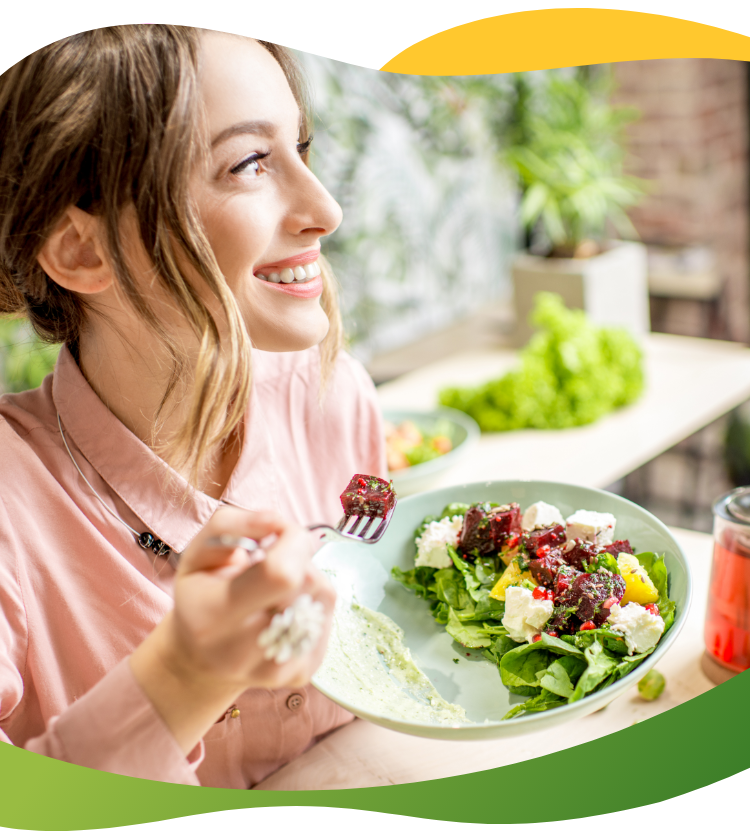 A young woman enjoying her salad and looking out the window
